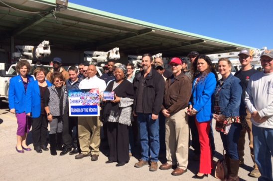 Members of the chamber's ambassadors, along with Entergy personnel who work at the Port Arthur Service Center, gathered near trucks in the yard for a photograph.